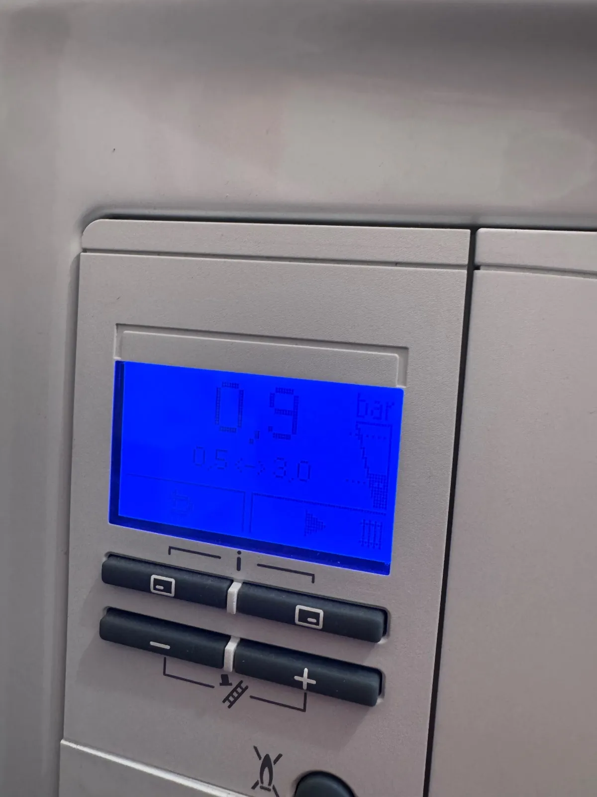 Boiler display with a blue backlight showing 0.9 bar, with a printed working range of 0.5 to 3.0 beneath the figure